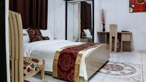 A hotel room with a bed, a desk, a chair, and a mirror. - Hill View Hotel McCarthy Hills (Mallam)