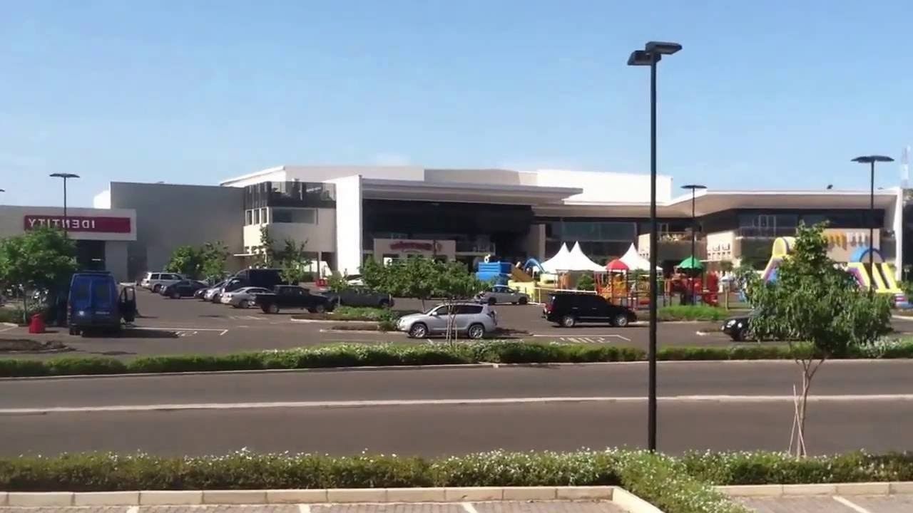 A parking lot with several cars, a building with a sign reading "YTIT 1301", and a playground with colorful equipment.