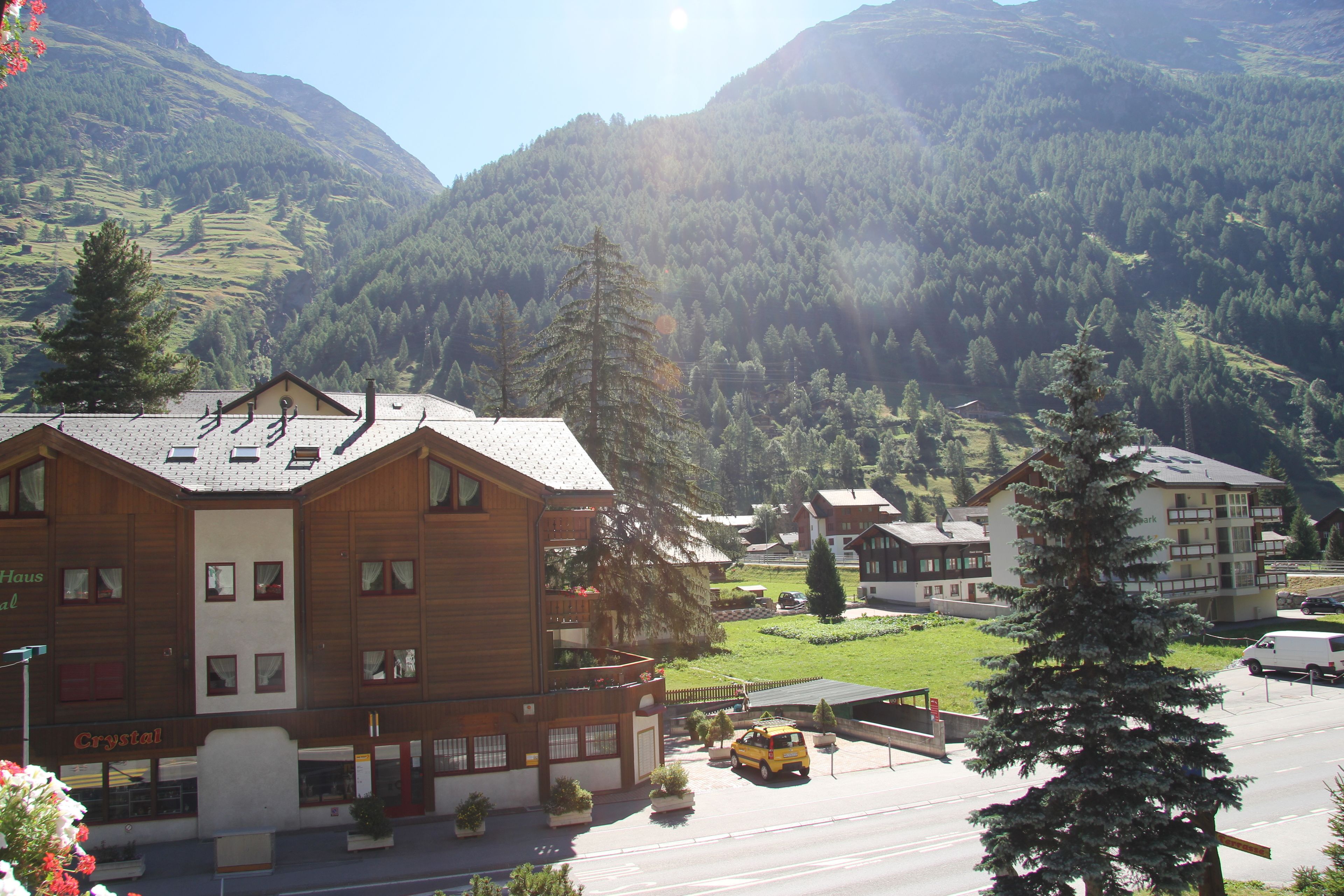 A hotel with a wooden facade, multiple balconies, and a parking area.