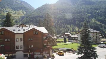 A hotel with a wooden facade, multiple balconies, and a parking area.