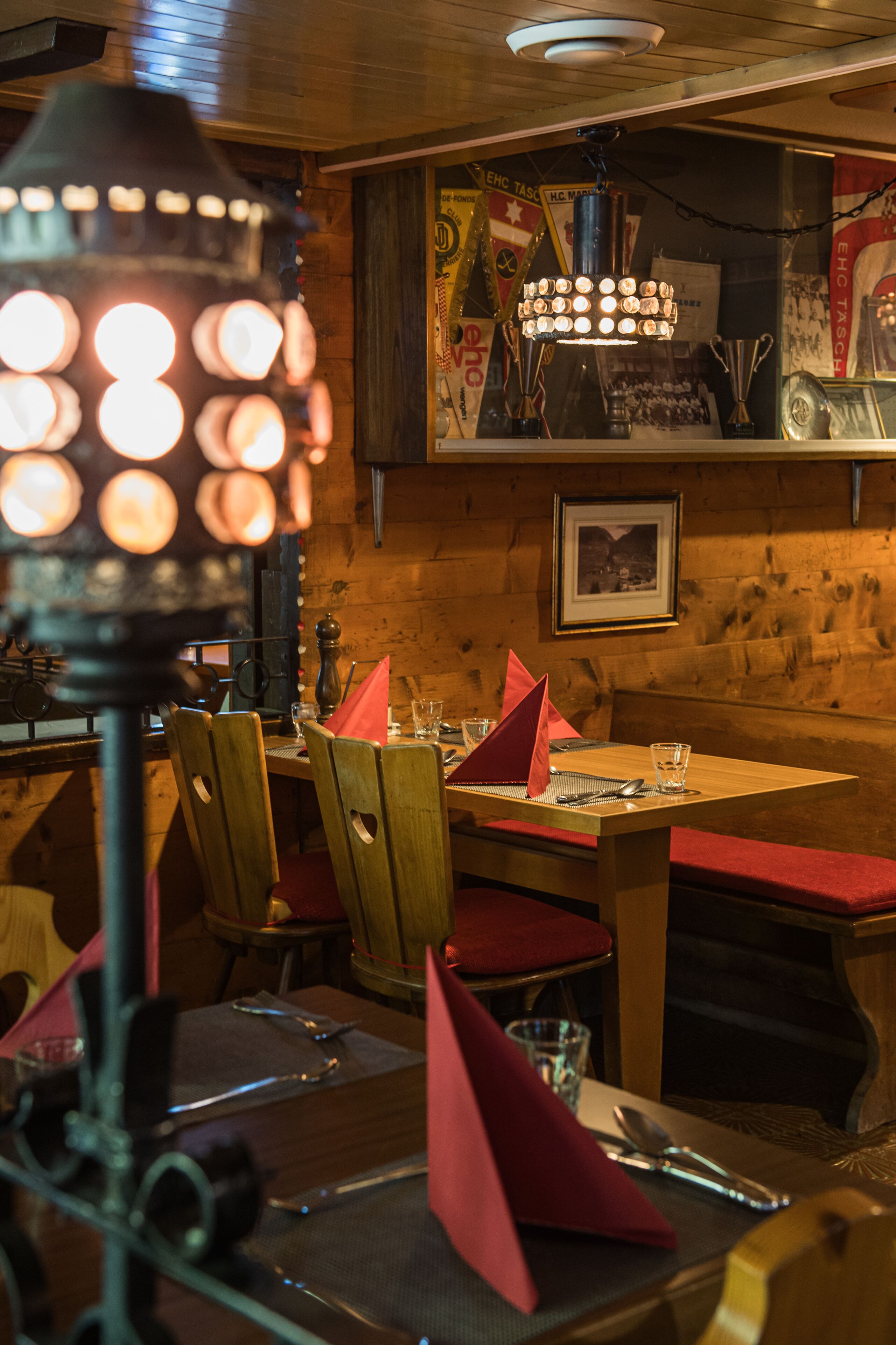 Zona pranzo con pareti in legno, un tavolo apparecchiato per due e un lampadario.