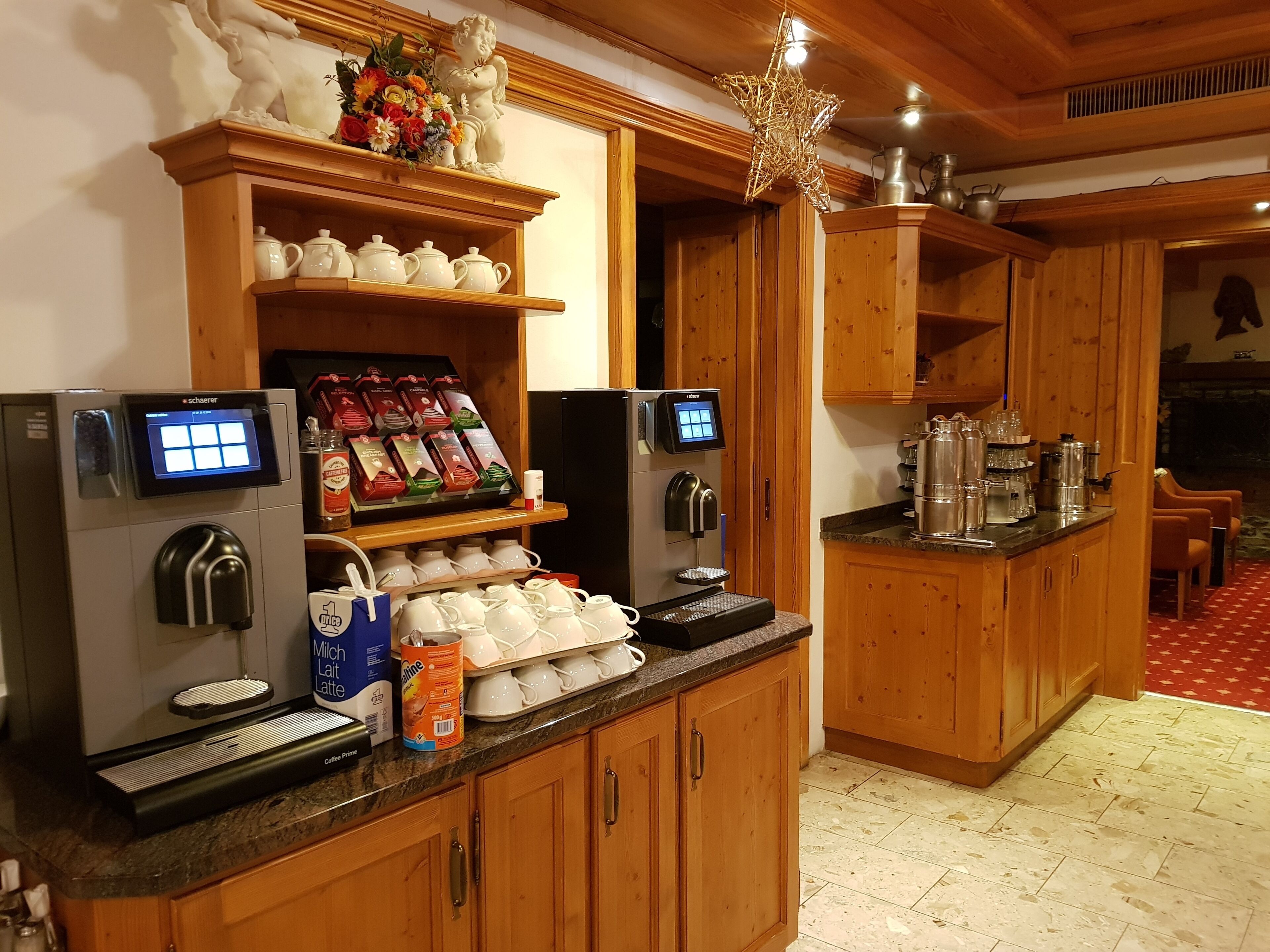 Una estación de café con varias máquinas de café, una selección de cápsulas y una variedad de tazas.