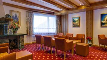 A cozy room with a fireplace, comfortable seating, and artwork on the walls.