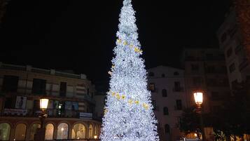 Un grande albero di Natale illuminato in un contesto urbano.