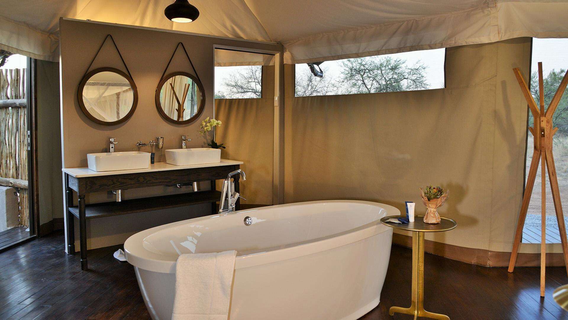 A modern bathroom with a freestanding bathtub, two sinks, and a vanity.
