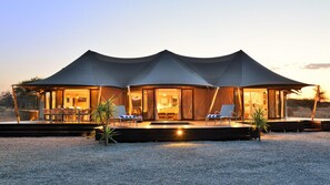 Un alojamiento tipo tienda de campaña, amplio y con varias habitaciones, cuenta con una zona de estar cubierta al aire libre y una piscina.