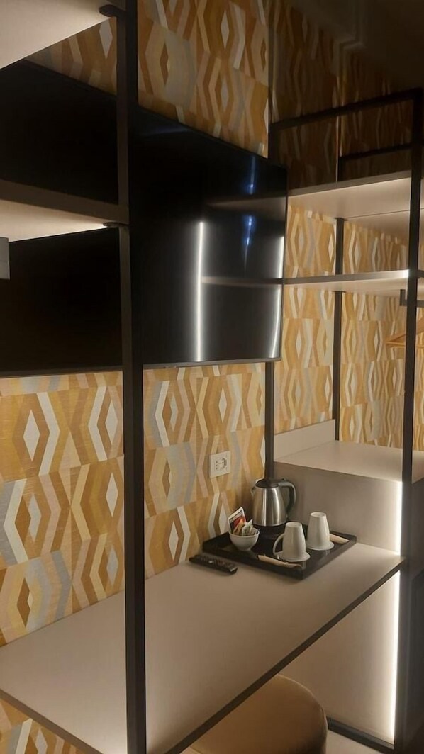 A bunk bed with a metallic headboard, a tray with a kettle, cups, and a remote control. - Green Park Bologna Residence (Granarolo dell'Emilia)