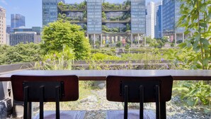 Un edificio moderno con múltiples fachadas de vidrio y jardines en la azotea.
