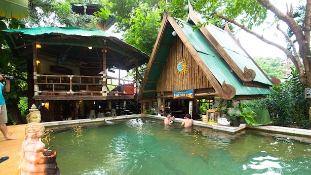 A pool area with a wooden structure and a statue.