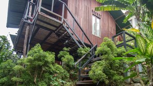 A wooden house with a staircase leading to a balcony.