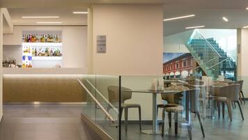 A modern interior with a bar area, seating, and a staircase.