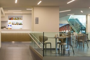 Un interior moderno con una zona de bar, asientos y una escalera.