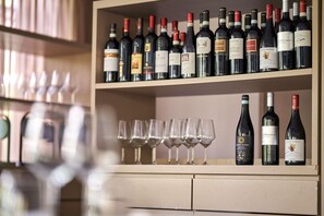 A wine rack with multiple bottles and glasses. - UNA Hotels Bologna Fiera (Bologna)