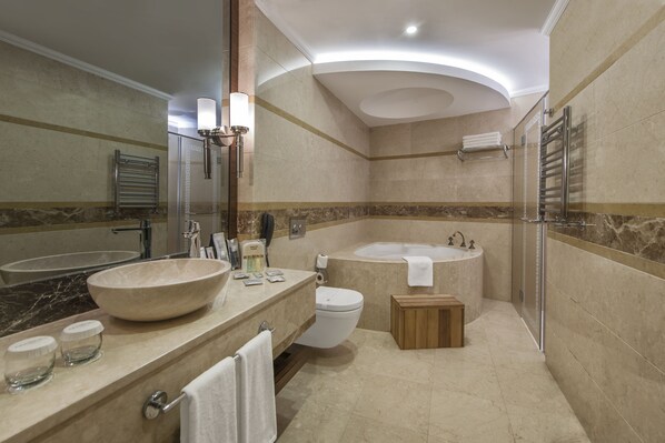 A modern bathroom with a large bathtub, a separate shower area, and a vanity with a large bowl sink. - Akrones Thermal Spa Convention Hotel (Afyonkarahisar)