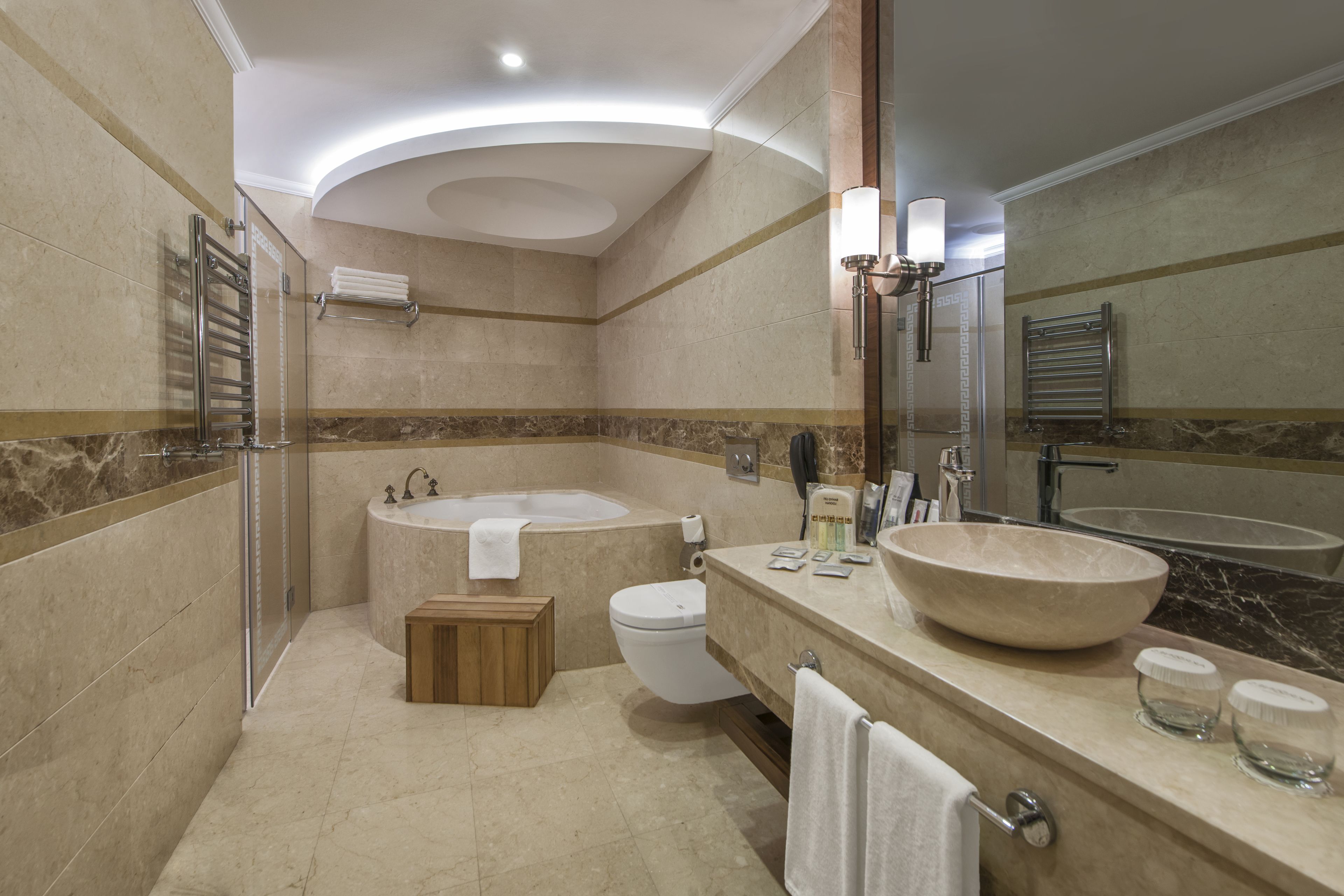 Un baño moderno con una bañera, un lavamanos grande y un inodoro.