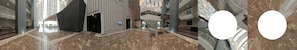 A spacious lobby with high ceilings, marble flooring, and modern furnishings.