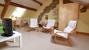 A cozy attic room with exposed wooden beams, a stone staircase, and a large wardrobe. - Centre of Britain Hotel & Restaurant (Haltwhistle)