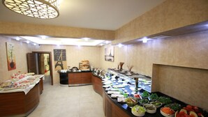A buffet area with various food items and a decorative Eiffel Tower sign. - Hotel Business Han (Nevsehir)