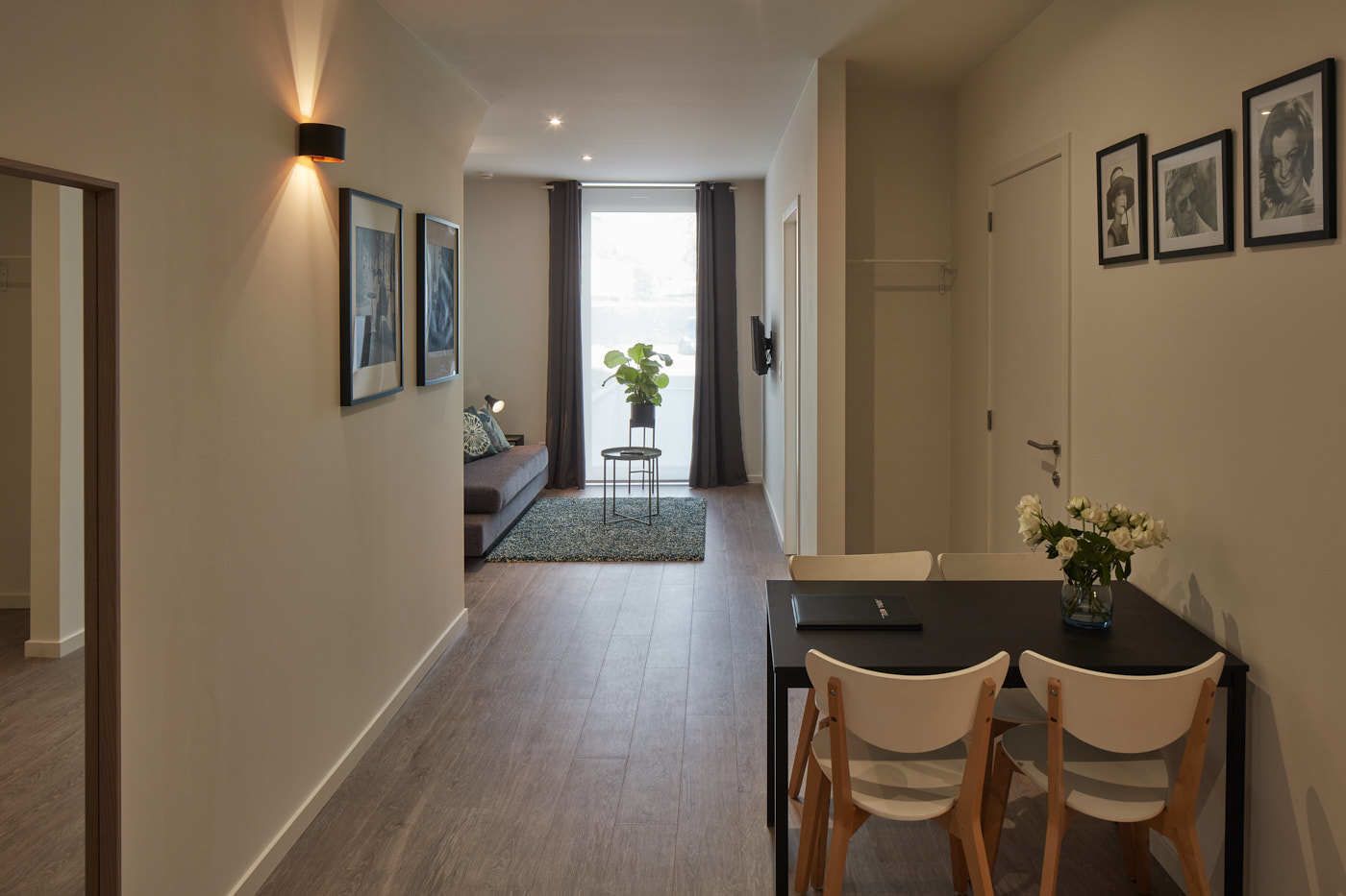 Un apartamento moderno con comedor, sala de estar y un ventanal grande.