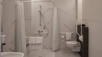 Une salle de bain moderne équipée d’une douche, de toilettes et d’un lavabo.