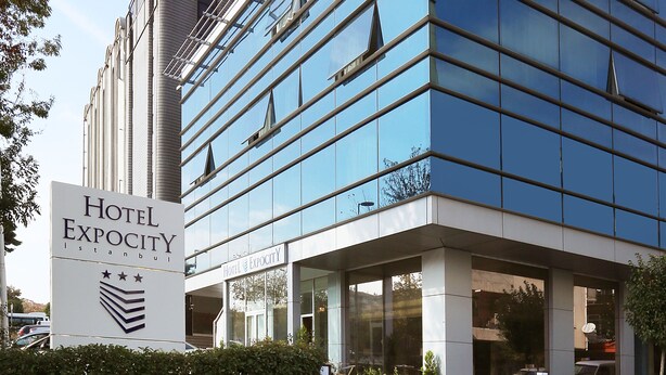 Un hôtel moderne, avec une façade en verre et une enseigne indiquant qu’il s’agit de l’hôtel Exocity, à Istanbul.