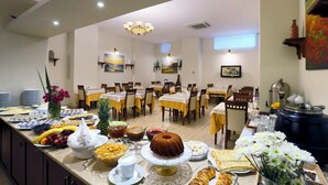 Un buffet proposant une variété de plats et un gâteau central placé sur une table.