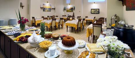 A buffet setup with various food items and a central cake on a table.