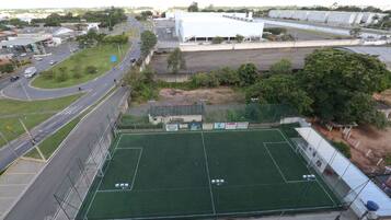 Un amplio campo deportivo con un perímetro cercado, rodeado de calles y edificios.