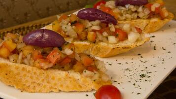 A plate of bruschetta topped with diced tomatoes, onions, and olives.