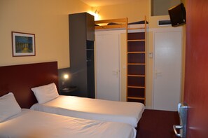 Habitación de hotel con dos camas, un armario, un televisor y un cuadro en la pared.