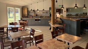Um restaurante moderno com uma ilha central, cadeiras e mesas de madeira.