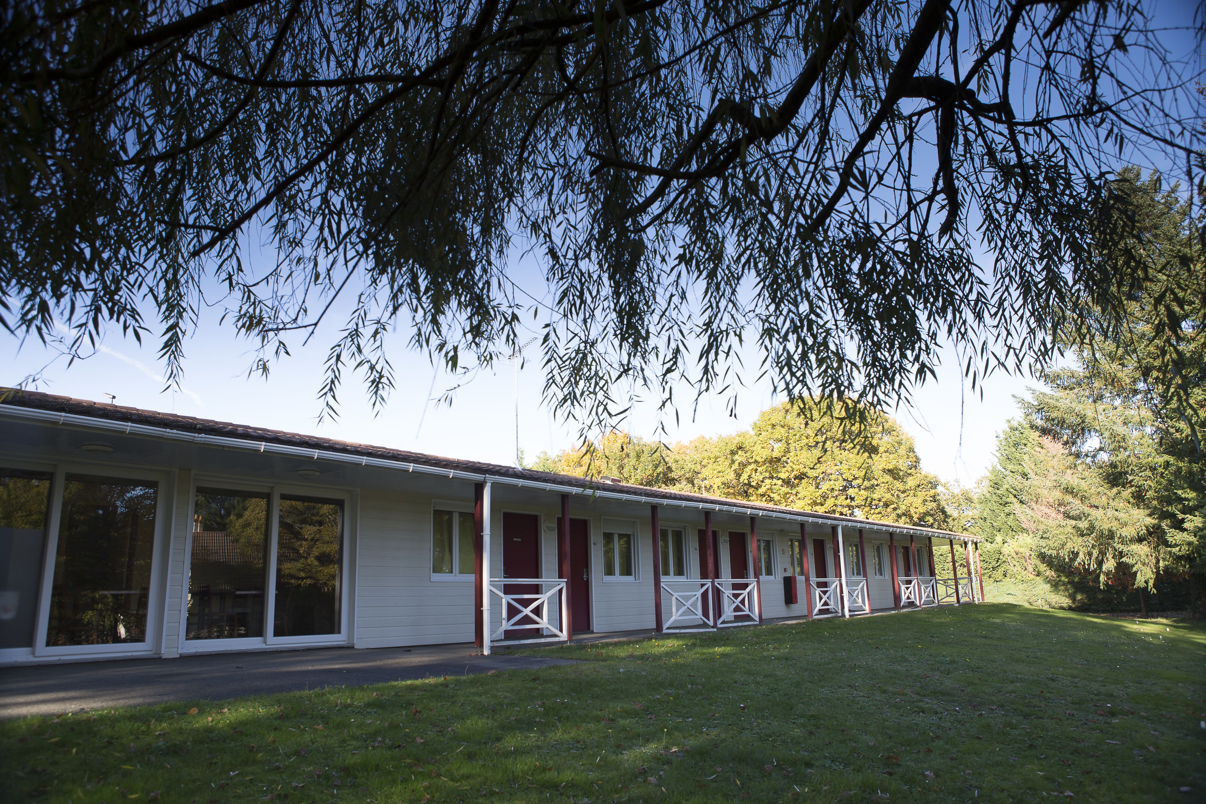 A row of single-story mobile homes with large windows and a covered porch area.