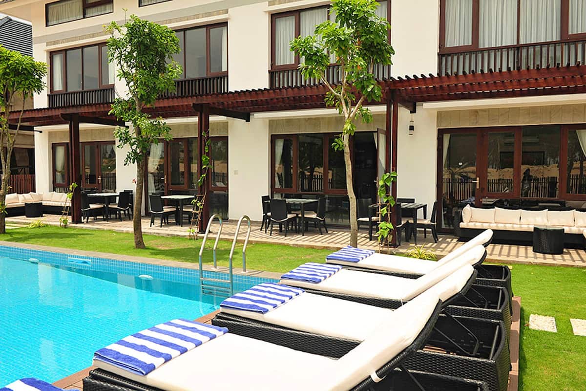A poolside area with lounge chairs, a pool, and outdoor seating.