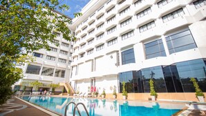 Un hotel con piscina, varios balcones y un diseño arquitectónico moderno.