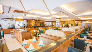 Un moderno vestíbulo de hotel con una barra central, espacios de estar y un escenario para presentaciones en vivo.