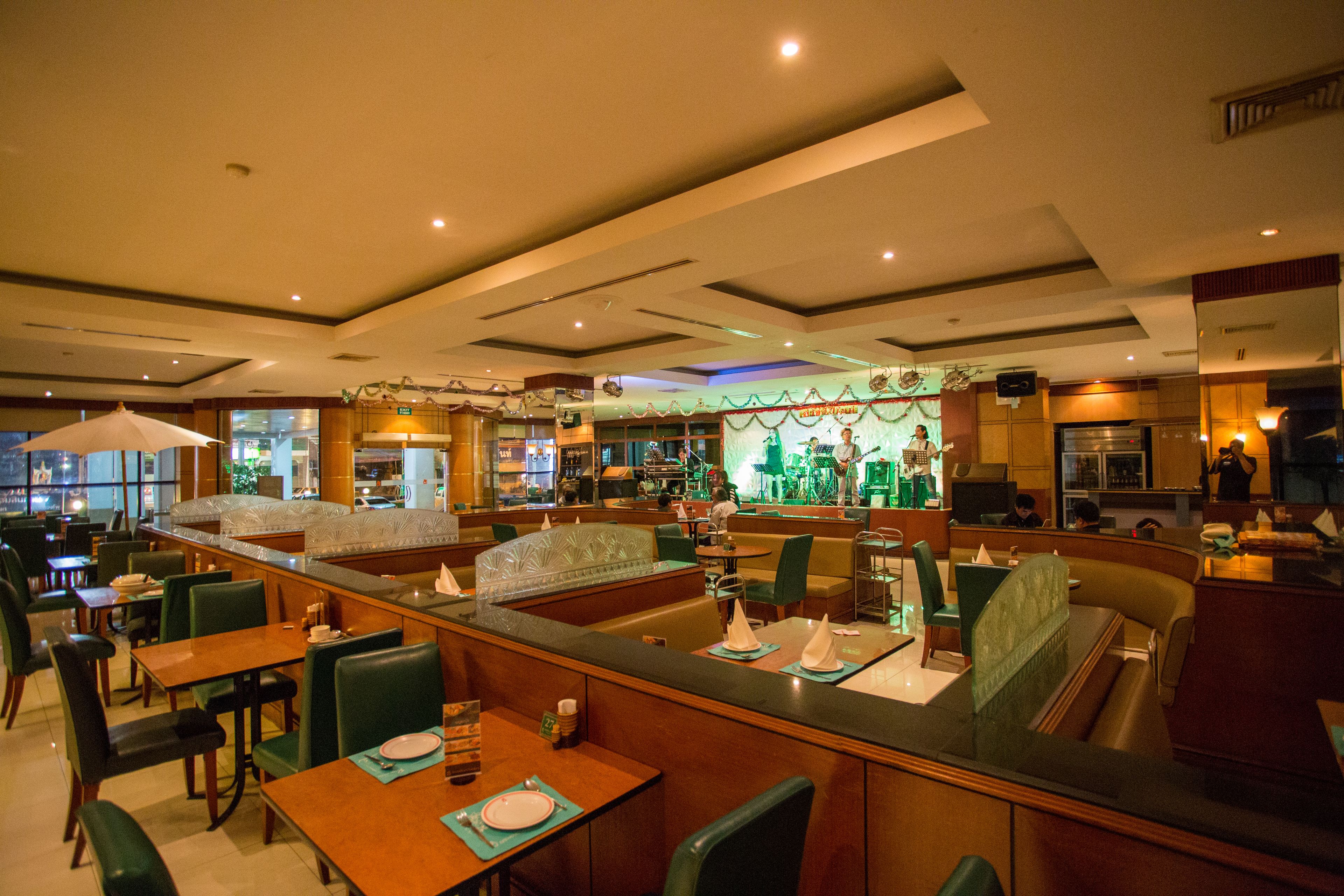 A restaurant with booths and tables, a bar area, and a view of the street outside.