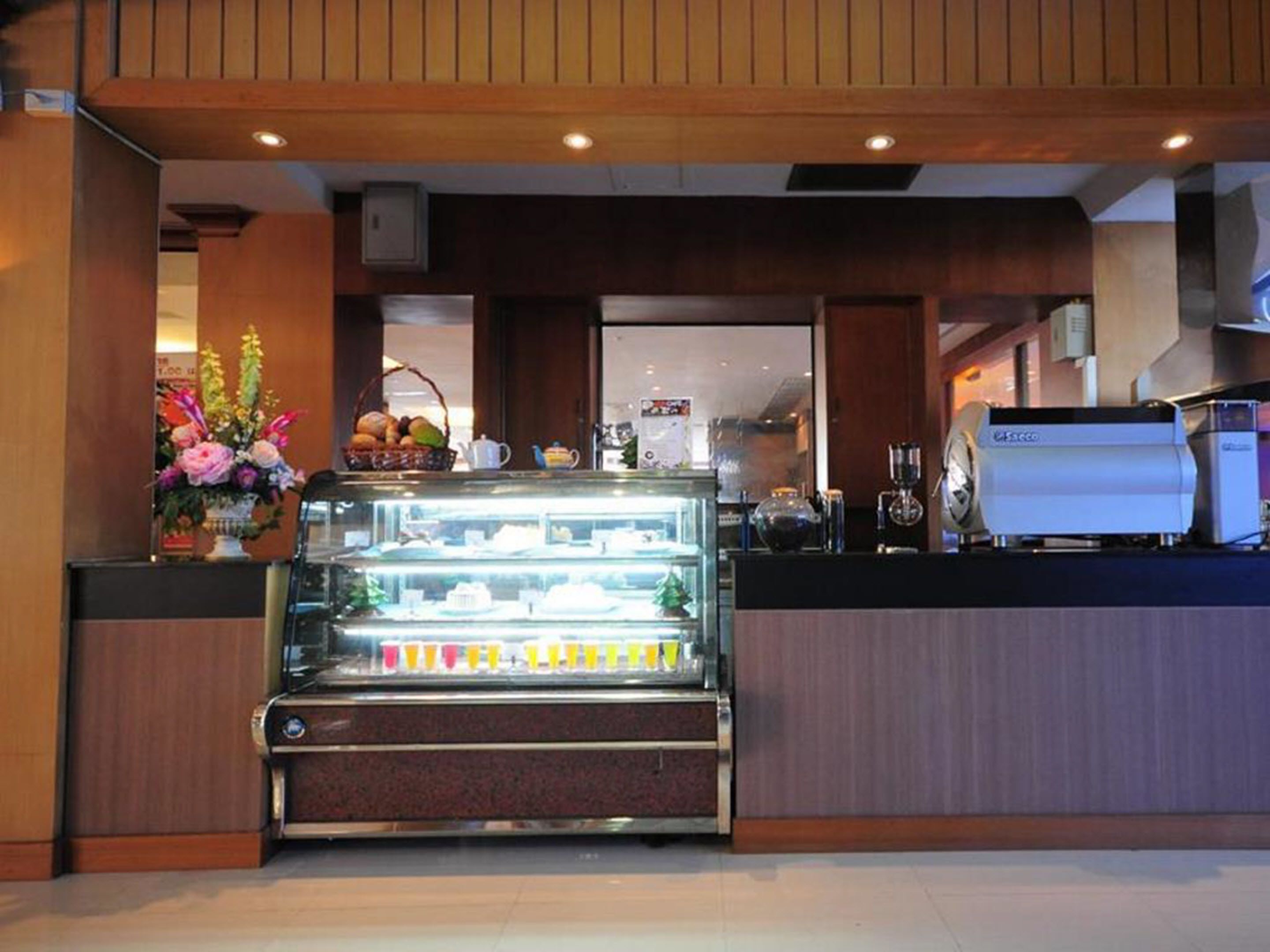 Vitrina de pastelería con productos de repostería y una máquina de café.