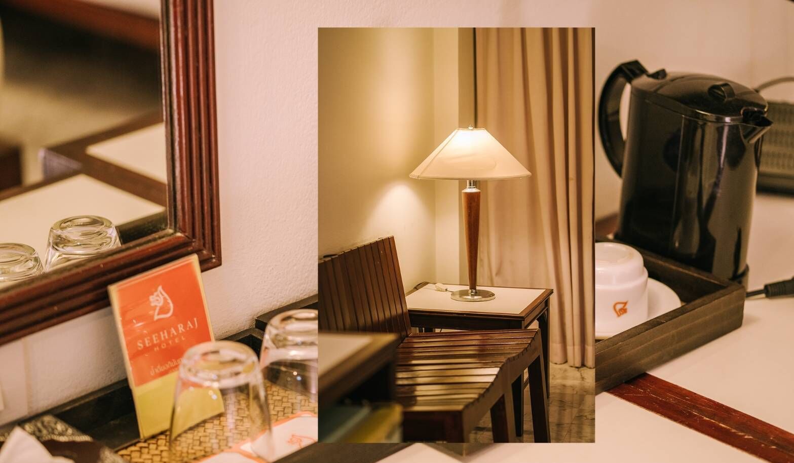 A hotel room with a wooden side table, a lamp, a coffee maker, a minibar, and a framed picture of the hotel.