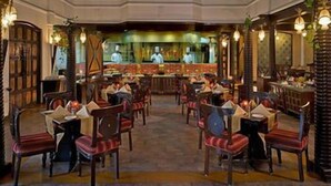 Un restaurant amb zona de bar, diverses taules i cadires.