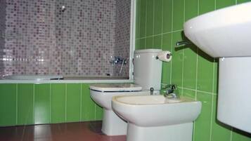 Un baño con inodoro, bidé y lavamanos.