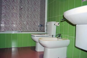 Un baño con inodoro, bidé y lavamanos.