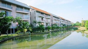 A multi-story hotel with balconies, a canal in front, and a bridge. - The Leela Resort & Spa Pattaya (Pattaya)