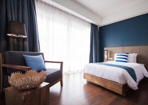 Une chambre d’hôtel moderne avec un lit en bois, une chaise agrémentée d’un vase décoratif et une grande fenêtre ornée de rideaux légers.