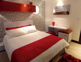 Un dormitorio con cama, escritorio y silla.