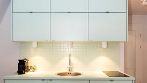 A modern kitchen with a built-in sink, a coffee machine, and a toaster. - Villa Riedenburg Design Apartments (Salzburg)