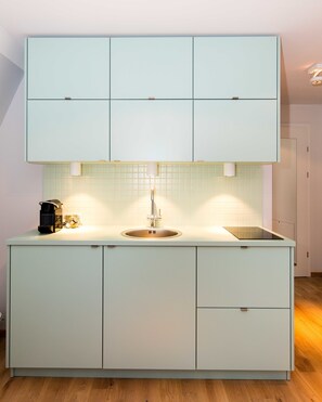 A modern kitchen with a built-in sink, a coffee machine, and a toaster.