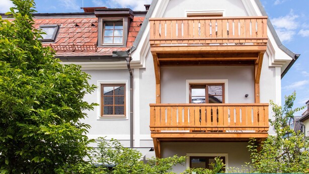 A two-story building with a balcony and a red-tiled roof. - Villa Riedenburg Design Apartments (Salzburg)