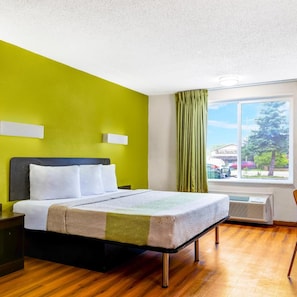 A hotel room with a bed, a nightstand, a window with curtains, and a view of the outside. - Motel6 Indianapolis, IN (Indianapolis)