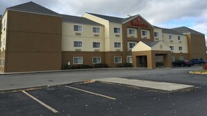 A Ramada hotel with a parking lot and a clear sky. - Ramada By Wyndham Coeur D'alene (Coeur d'Alene)