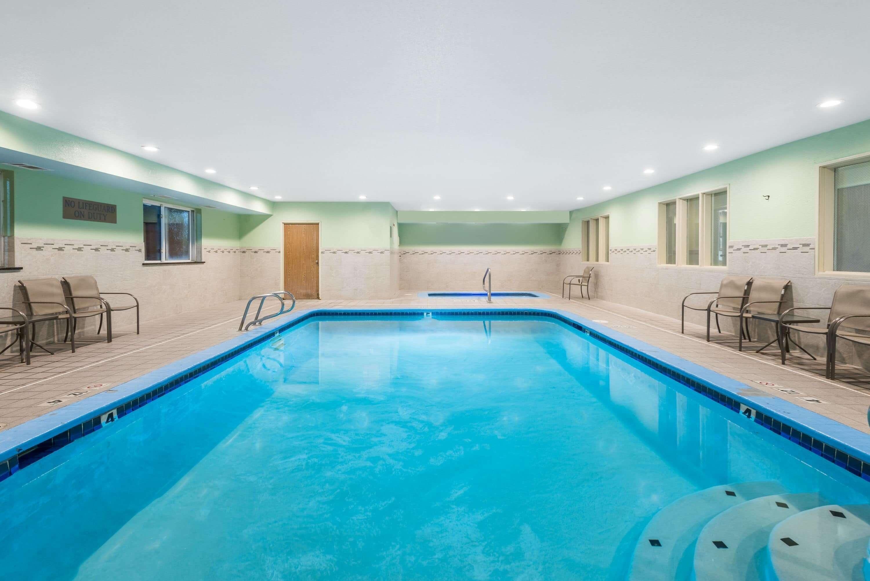 A swimming pool with chairs and a door.